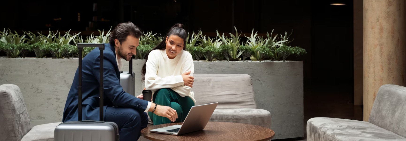 A girl and a guy talking near laptop